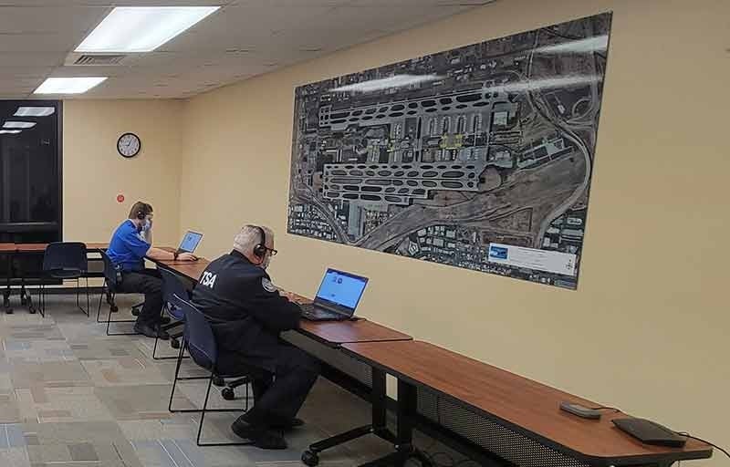 People seated at a table working on laptops.