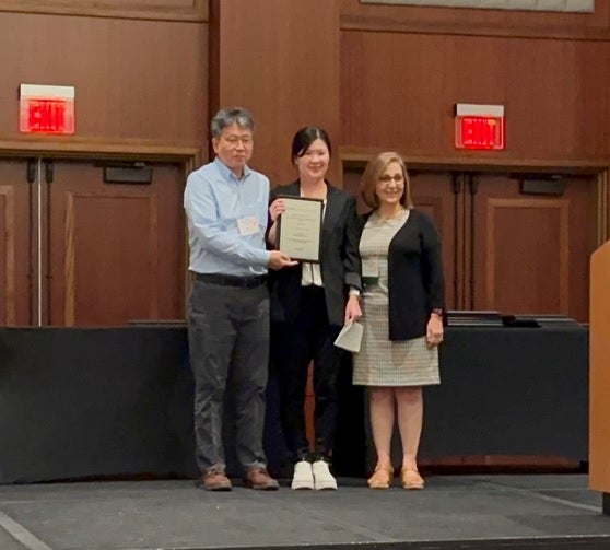 ASU Red Avenue Foundation Professor Pei-yu “Sharon” Chen standing onstage holding a certificate.