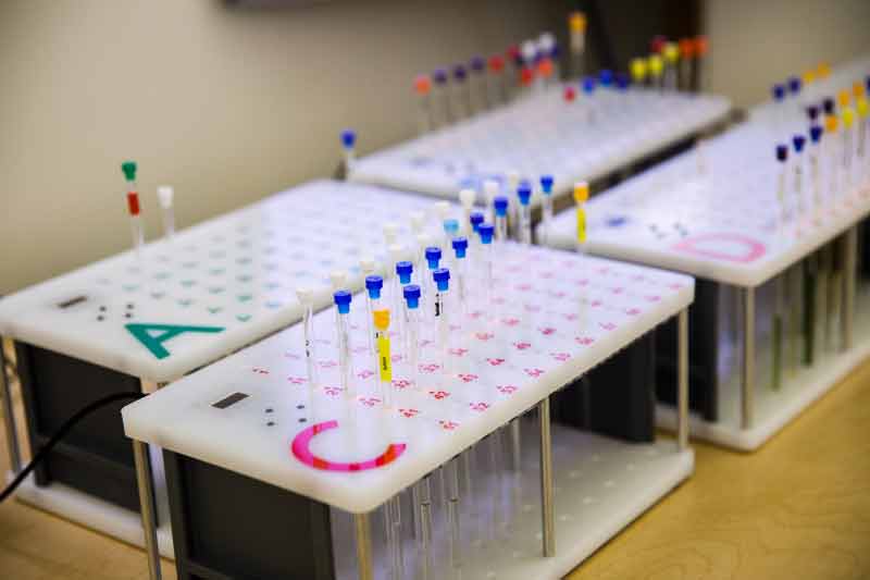 a rack of small vials filled with samples for NMR testing