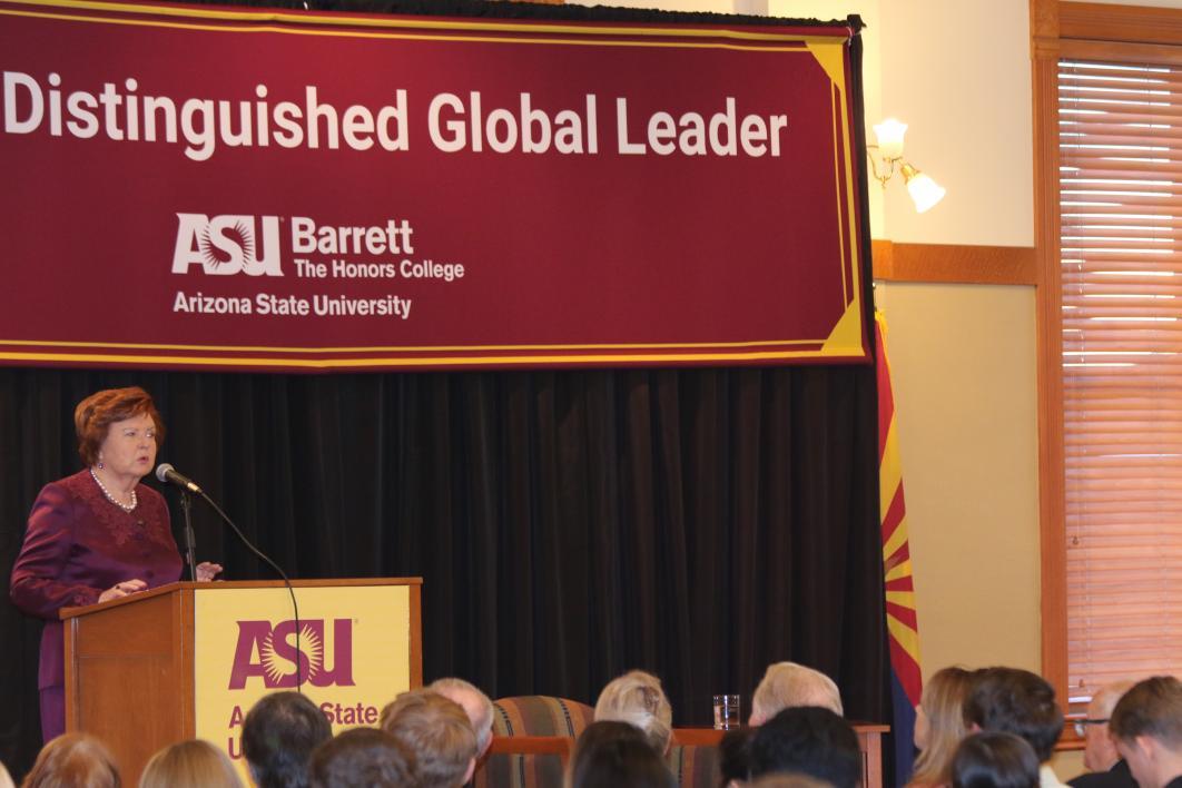 woman speaking to audience at podium