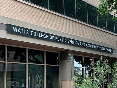 Exterior of a building with the words "Watts College of Public Service and Commnity Solutions."