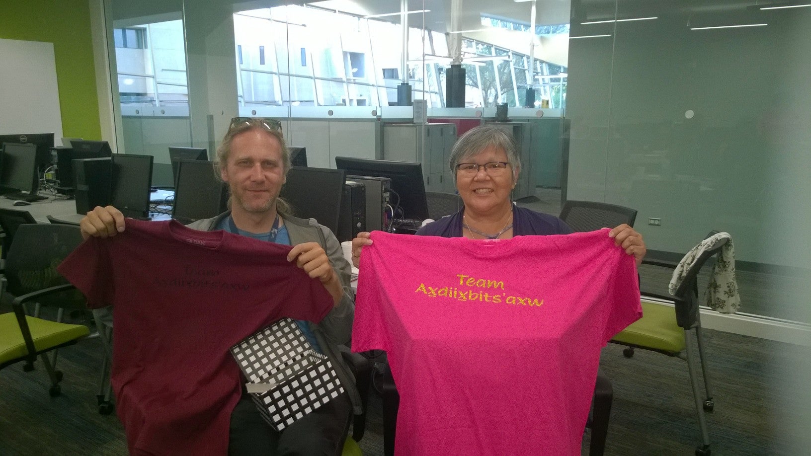 two people holding up tshirts